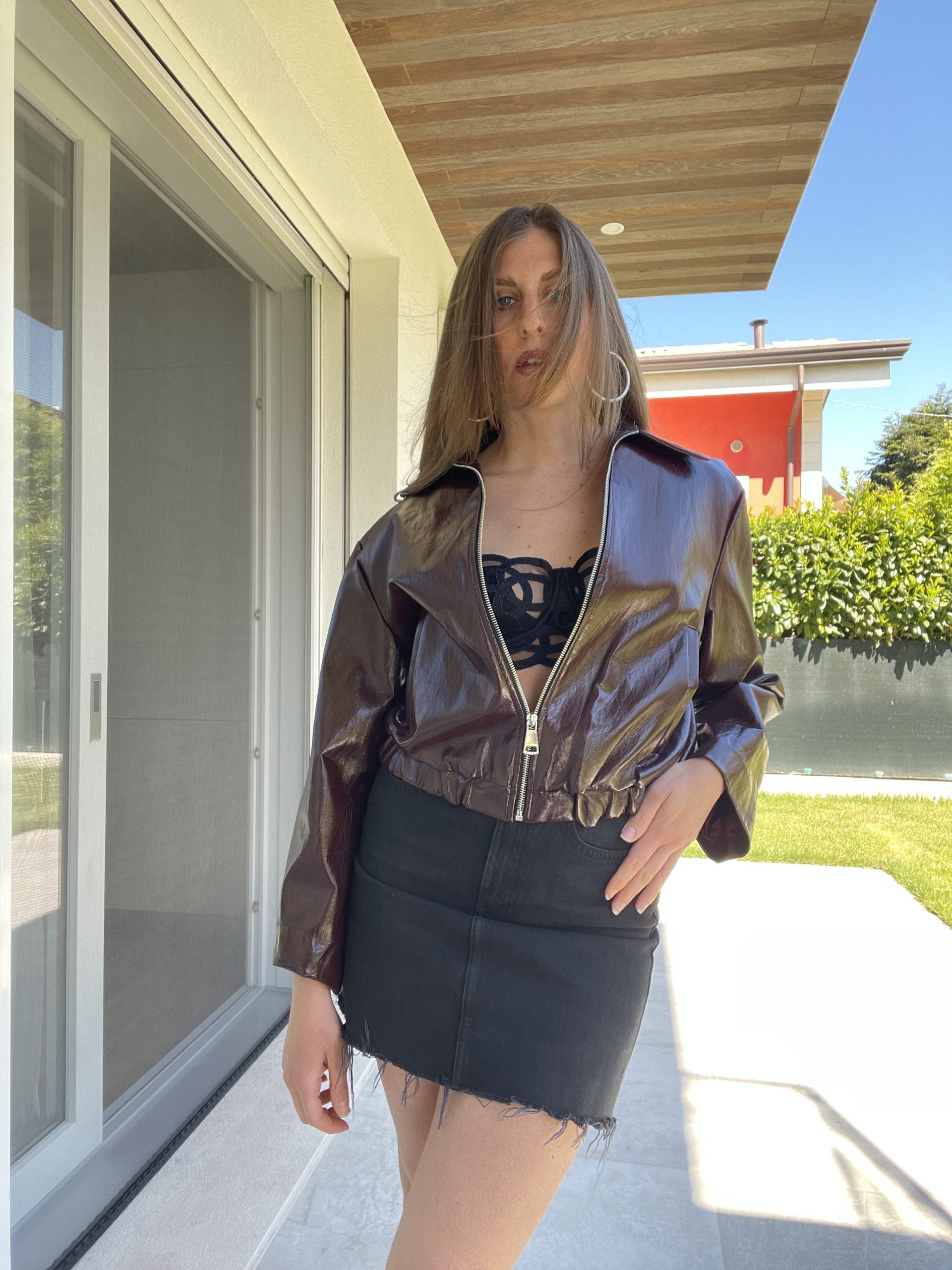 Giacca bomber in ecopelle effetto vernice bordeaux modello corto